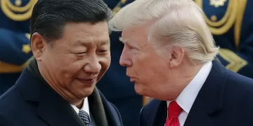 President Trump chats with Chinese President Xi Jinping during a visit to Beijing in 2017. Andy Wong/AP