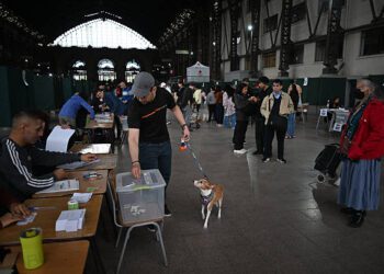 Un hombre con un perro emitió su voto durante la segunda sedición de las elecciones presidenciales en la Estación de Mapocho en Santiago el 14 de diciembre de 2025. Los chilenos se dirigen a las urnas para una resección presidencial entre Jeannette Jara, una comunista respaldada por una amplia coalición de izquierda, y José Antonio Kast, un devoto político de extrema derecha que promete una línea dura en seguridad y migración. (Foto de Eitan ABRAMOVICH / AFP vía Getty Images)